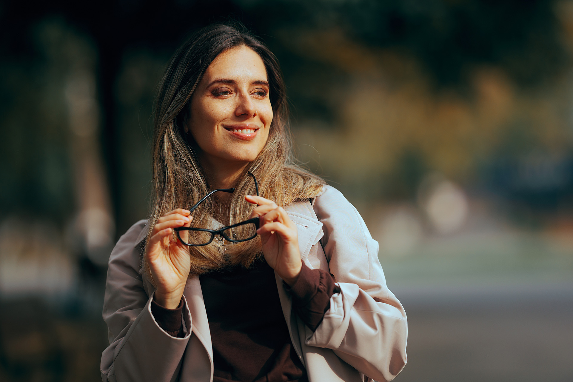 Woman holding her glasses, not needing them anymore